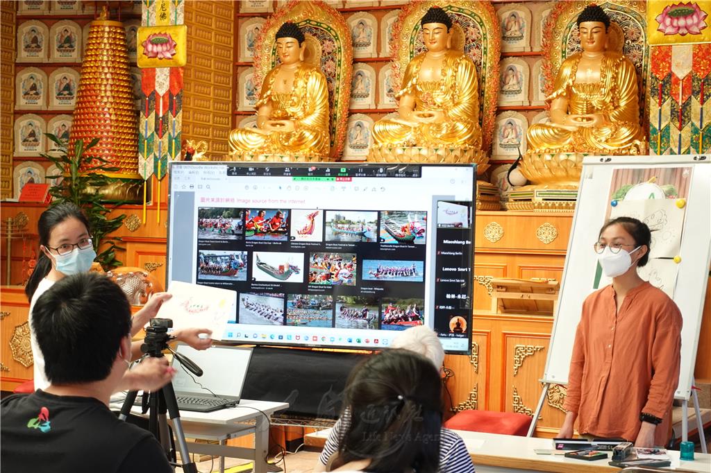 王小麗（左）分享現場「藝術家」的龍舟作品給線上的參與者