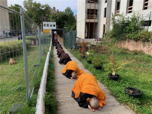 妙祥法師引領大眾朝山，佛號聲聲入耳，俯身輕觸一路的石材、木條等，大眾皆虔誠禮拜於佛陀足下。