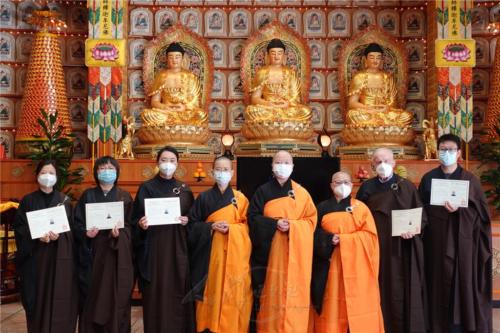 求受五戒的戒子得償所願，歡喜地持著證書與法師們合照