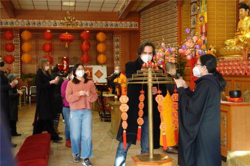 中西方人士於佛前獻燈