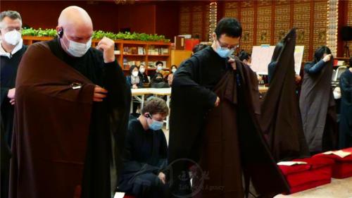 受三皈羯磨後，12位佛子秉宣五戒，披搭縵衣