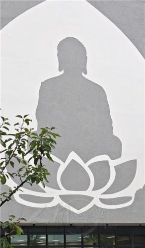 在面向戶外舞台的牆面上，灰白二色的大佛像，接引著來來往往的人士