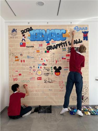 大會設計一面「佛光塗鴉牆」，有人畫上自己的國旗、有的寫下歡迎詞，也有人寫下「佛教靠我，永不退票」，展示了傳承信仰，弘揚佛法的決心，也成為一幅來自全球五大洲青年的集體創作作品