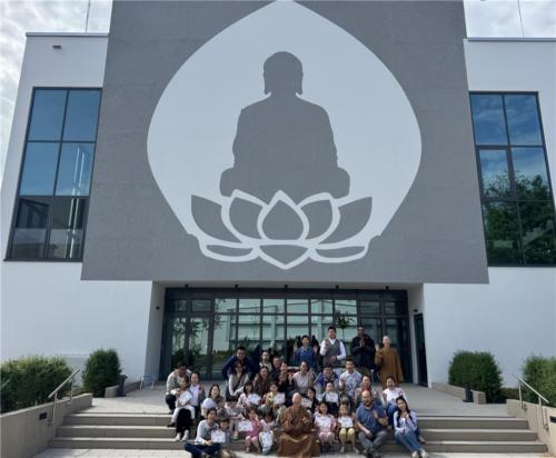 法師們與參與親子烘焙的家長、小朋友們於柏林佛光山禪園大佛前合影