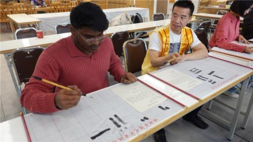 柏林協會唐雪峰副會長為印度青年解說中文字的筆順