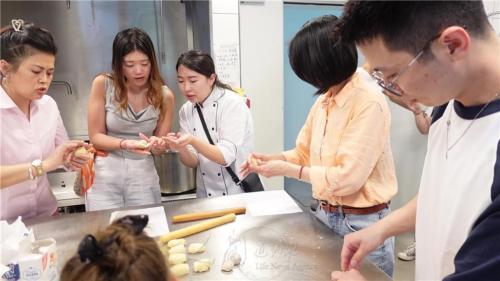 佛光大學蔬食系楊雅筑同學手把手指導青年將麵皮包住餡料