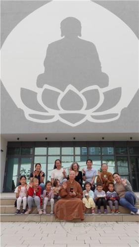 柏林菩提園小朋友拿著今天製作完成的果醬與家長及法師們合影