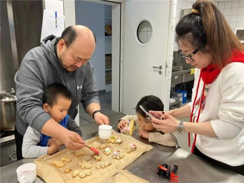 金航（左二）認真觀摩爸爸怎麼為耶誕餅上色