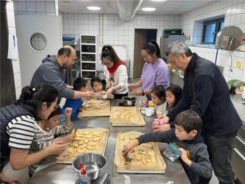 孩子們在大寮裡跟著爸爸媽媽們揉麵、壓模、裝飾，忙得不亦樂乎