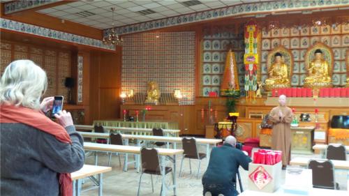 法師應攝影師要求在佛前合掌拍照