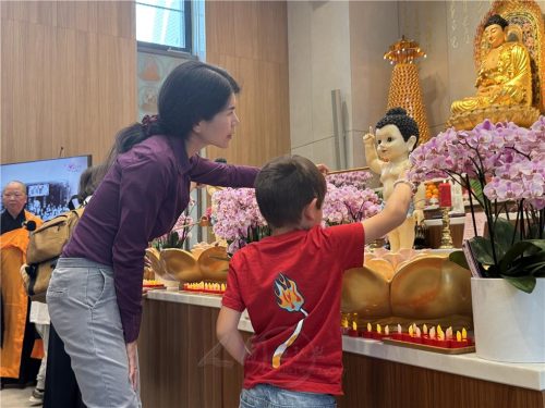 愛心媽媽王榕（左）指導孩童浴佛